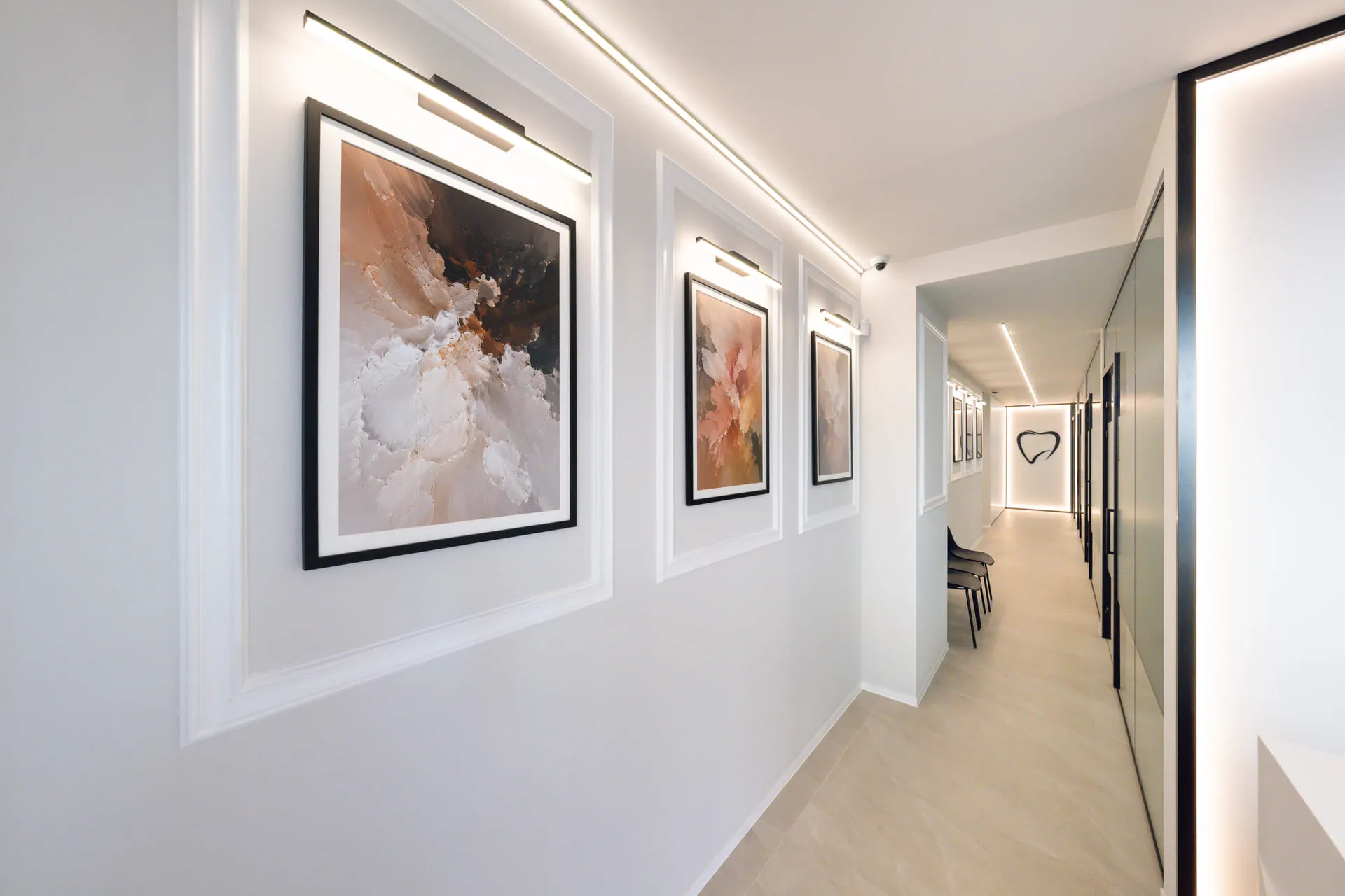Le couloir d’accueil réel de NovaCare Dental à Jette, avec les tableaux et le logo du cabinet.