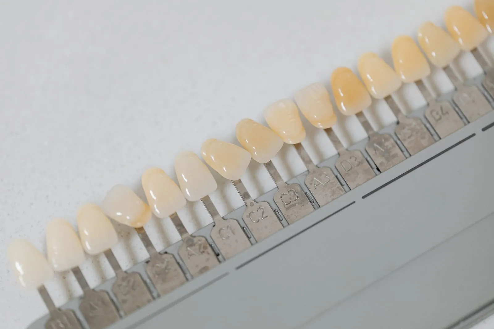 Échantillons d'un nuancier de teintes dentaires alignés en diagonale.